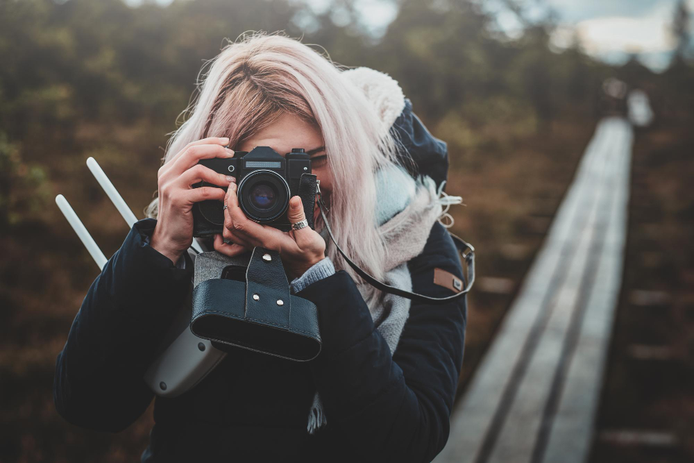 skupiona-blondynka-robi-zdjecie-aparatem-fotograficznym-podczas-spaceru-po-parku